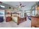 Comfortable main bedroom featuring hardwood furniture, ceiling fan and bright windows at 1037 Beckley Cir, Venice, FL 34292