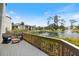 Back deck overlooking the lake featuring chairs, a bench, tropical landscaping and a fountain at 1156 Bird Bay Way # 104, Venice, FL 34285