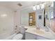 Tiled bathroom with a tub, toilet, vanity with sink and a large mirror at 1156 Bird Bay Way # 104, Venice, FL 34285