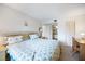 Cozy bedroom featuring a bed with a floral comforter, a desk and a view into the bathroom at 1156 Bird Bay Way # 104, Venice, FL 34285