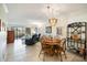 Open dining area with stylish chandelier and views of the living room and lanai at 1156 Bird Bay Way # 104, Venice, FL 34285