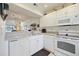 Kitchen with bright white cabinets, modern appliances, and granite countertops at 1156 Bird Bay Way # 104, Venice, FL 34285