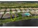 Aerial view of a beautiful home with a tile roof, a community pool and lake access, perfect for relaxation at 11648 Okaloosa Dr, Venice, FL 34293
