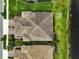 Overhead shot highlighting a home with a patterned roof, brick driveway, and serene lakeside views at 11648 Okaloosa Dr, Venice, FL 34293