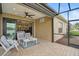 Relaxing covered patio with comfortable seating, ceiling fan, and views of the serene lake at 11648 Okaloosa Dr, Venice, FL 34293
