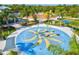 Aerial view of a community splash pad with colorful water features, surrounded by palm trees and seating at 11648 Okaloosa Dr, Venice, FL 34293