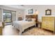 Bright bedroom with neutral decor, woven headboard, dresser, and balcony access at 1190 Bird Bay Way # 309, Venice, FL 34285