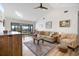 Bright living room featuring a vaulted ceiling, ceiling fan, comfortable seating, and sliding glass doors to the balcony at 1190 Bird Bay Way # 309, Venice, FL 34285