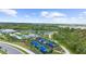 Aerial view of the community offering a pool, lake, tennis courts and clubhouse in a landscaped setting at 12450 Somatic Ct, Venice, FL 34293
