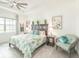 Well-lit bedroom with patterned quilt, ceiling fan, and leafy decor at 12548 Wellen Golf St, Venice, FL 34293