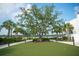 Lawn area with a large mature oak tree and landscaping along the water in a walkable downtown area of Wellen Park at 12548 Wellen Golf St, Venice, FL 34293