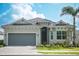 Charming single-story home features a gray exterior, well-manicured lawn, and a two-car garage at 12548 Wellen Golf St, Venice, FL 34293