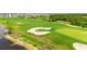 Beautiful golf course with well-maintained fairways, a pristine sand trap, and a scenic lake in the background for an elevated experience at 12548 Wellen Golf St, Venice, FL 34293