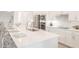 Modern kitchen with stainless steel appliances, white cabinets, and a large island at 12548 Wellen Golf St, Venice, FL 34293