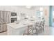 Modern kitchen features stainless steel appliances, an island, and white cabinetry at 12548 Wellen Golf St, Venice, FL 34293
