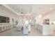 Bright open-concept living area with a large sofa and kitchen island with bar seating at 12548 Wellen Golf St, Venice, FL 34293