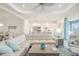 Bright open-concept living area with a large sofa and modern kitchen in the background at 12548 Wellen Golf St, Venice, FL 34293