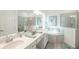 Beautifully appointed bathroom with dual sinks, a soaking tub, and a glass-enclosed shower offering luxury at 12548 Wellen Golf St, Venice, FL 34293
