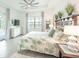 Bright main bedroom featuring tray ceilings, stylish décor, and ample natural light with a view of the patio at 12548 Wellen Golf St, Venice, FL 34293
