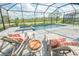 Inviting screened-in pool area with lounge chairs, a table, and a view of the lush greenery at 12548 Wellen Golf St, Venice, FL 34293