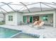 Expansive pool patio featuring multiple seating areas and a built-in grill, perfect for outdoor gatherings at 12548 Wellen Golf St, Venice, FL 34293