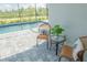 Charming poolside seating with wicker chairs, decorative pillows, and a lovely view of the sparkling blue pool at 12548 Wellen Golf St, Venice, FL 34293