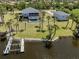 Aerial view of the property on a waterfront lot, featuring a pool, dock and lush landscaping at 13314 Prentice Ave, Port Charlotte, FL 33953