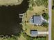 Aerial view of the waterfront home featuring a private boat dock and screened-in lanai at 13314 Prentice Ave, Port Charlotte, FL 33953