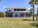 The rear exterior of the home has a screened lanai on both levels, surrounded by palm trees at 13314 Prentice Ave, Port Charlotte, FL 33953