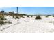 Sandy beach with vegetation, the lighthouse, picnic shelters, and the clear sky in the background at 13314 Prentice Ave, Port Charlotte, FL 33953