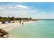 Lush, sandy beach scene featuring calm waters, scattered sunbathers, and vibrant beach umbrellas under a bright sky at 13314 Prentice Ave, Port Charlotte, FL 33953