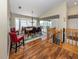 Well-lit dining room featuring wood floors, bay window, and adjacent staircase to the second floor at 13314 Prentice Ave, Port Charlotte, FL 33953