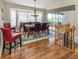Dining room features wood floors, large windows, and adjacent staircase to the second floor at 13314 Prentice Ave, Port Charlotte, FL 33953