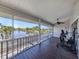 Large screened lanai with water views featuring exercise equipment, ceiling fan, and wooden floor at 13314 Prentice Ave, Port Charlotte, FL 33953