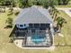Aerial view of the home featuring a screened-in lanai and kidney-shaped pool at 13314 Prentice Ave, Port Charlotte, FL 33953