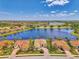 Stunning aerial view of homes on a lake with well-maintained lawns and mature landscaping at 138 Rimini Way, North Venice, FL 34275