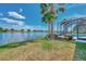 Lush backyard with lake view and screened-in lanai featuring a pool and well-manicured landscaping at 138 Rimini Way, North Venice, FL 34275