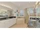Bright bathroom featuring dual sinks, a soaking tub, and a glass-enclosed shower with tile surround at 138 Rimini Way, North Venice, FL 34275
