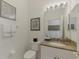 Well-maintained half bathroom features a sink with granite countertop and a toilet with decorative wall art at 138 Rimini Way, North Venice, FL 34275