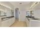 Well-lit bathroom featuring dual sinks, granite countertops, and bright mirrors at 138 Rimini Way, North Venice, FL 34275