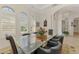 Bright dining room features a glass table, decorative rug, and lots of natural light through shuttered windows at 138 Rimini Way, North Venice, FL 34275