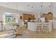 Bright dining area with glass table, woven chairs, and a view of the kitchen with breakfast bar at 138 Rimini Way, North Venice, FL 34275