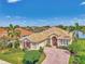 Attractive single-Gathering home boasts lush landscaping, a brick driveway, and a view of a lake at 138 Rimini Way, North Venice, FL 34275