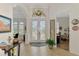 Bright foyer with tile flooring, glass double doors, and decorative chandelier at 138 Rimini Way, North Venice, FL 34275