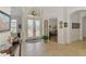 Bright foyer with tile flooring, glass double doors, and decorative chandelier at 138 Rimini Way, North Venice, FL 34275