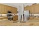 Well-equipped kitchen featuring stainless steel appliances and stunning granite countertops with light wood cabinets at 138 Rimini Way, North Venice, FL 34275