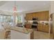 Open concept kitchen with tan cabinets, granite countertops, and stainless steel appliances at 138 Rimini Way, North Venice, FL 34275