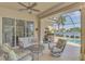 Relaxing outdoor space with comfortable seating and a partial view of the pool and serene water feature at 138 Rimini Way, North Venice, FL 34275