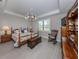 Cozy bedroom with wooden furniture, a tray ceiling, and natural light from the window at 13908 Vadini St, Venice, FL 34293