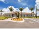 Clubhouse exterior with parking including accessible spaces, a tiled roof, and well-manicured landscaping at 13908 Vadini St, Venice, FL 34293